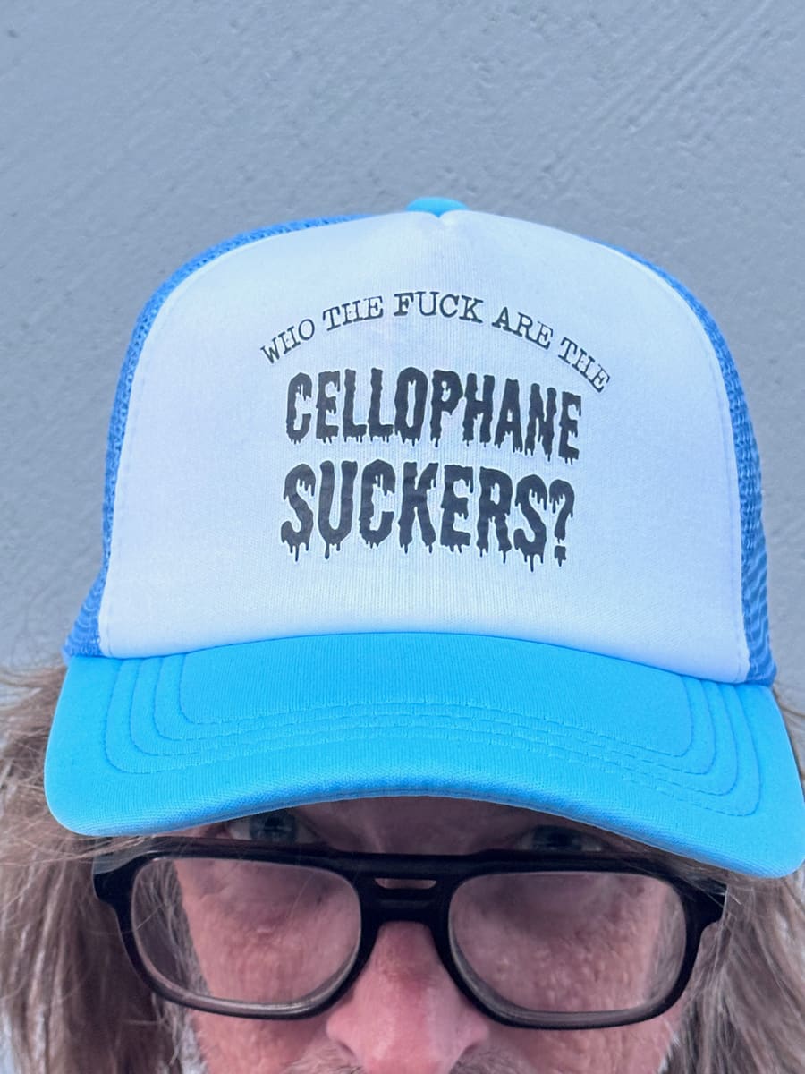 Blue and white trucker cap printed Who the fuck are the Cellophane Suckers?