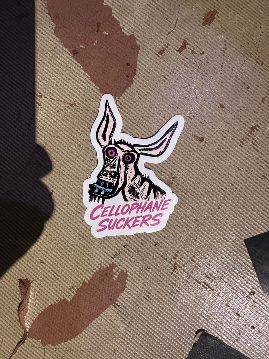 Die-cut sticker of a donkey head with the band name in pink